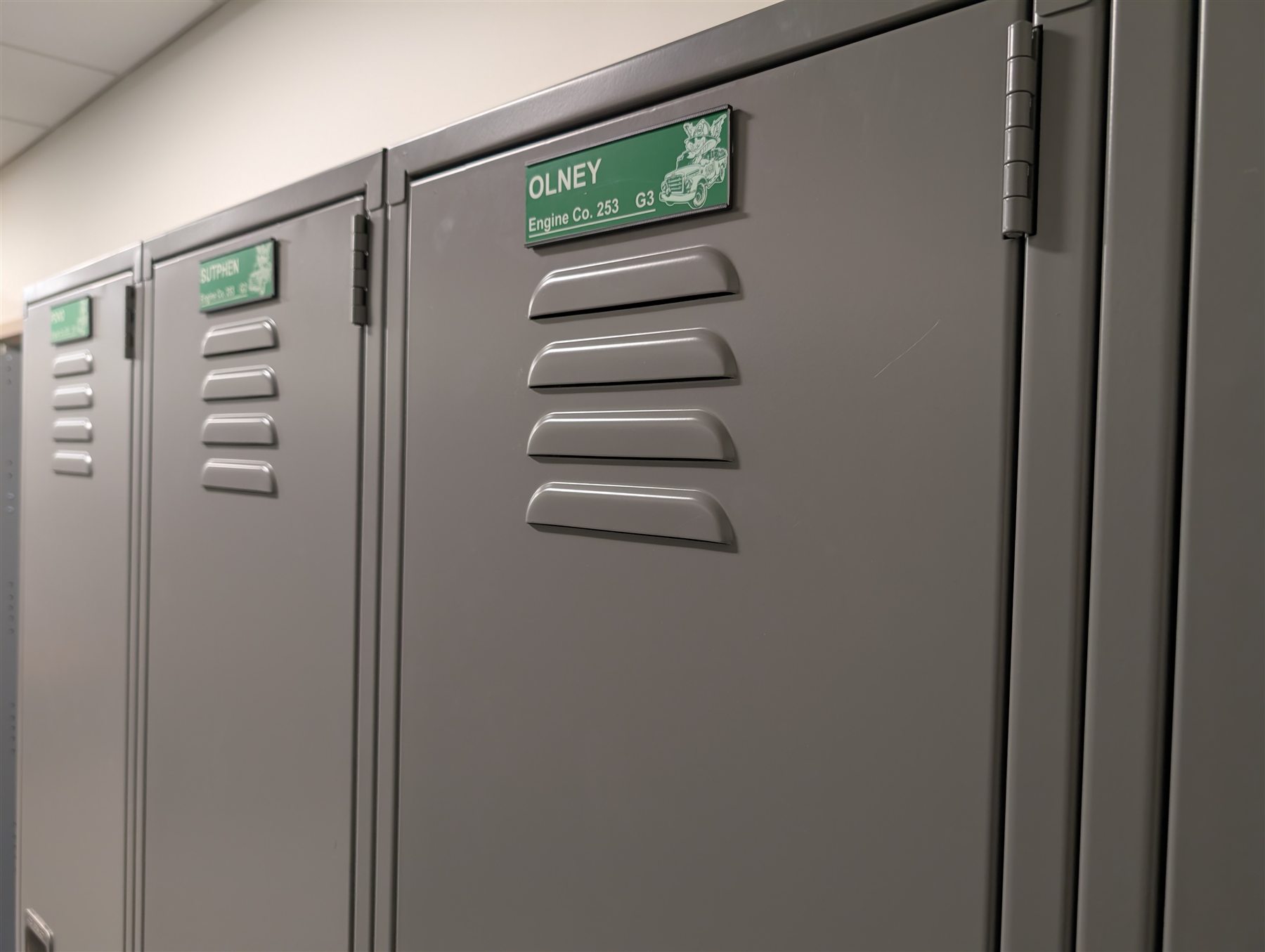 Coordinated personalized nameplates installed across a row of fire department gear lockers